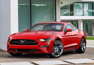 a red 2018 ford mustang in a driveway