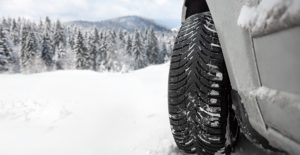 a close up an suv tire driving over snow