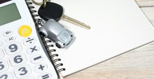 a calculator and car keys symbolize car financing