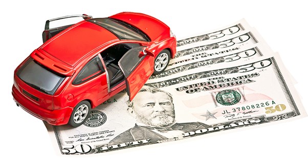 a concept image of a toy car on top of bills symbolizing car financing