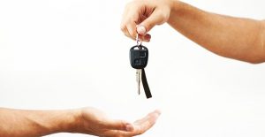 a person hands over car keys to another individual symbolizing liability auto insurance coverage