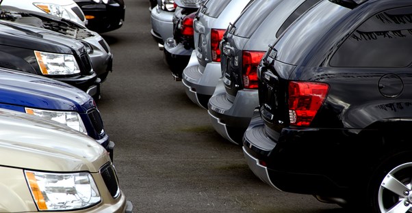 a row of cars in a dealership ready for trade in