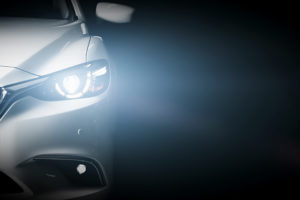 light shines from the headlight of a luxury sedan
