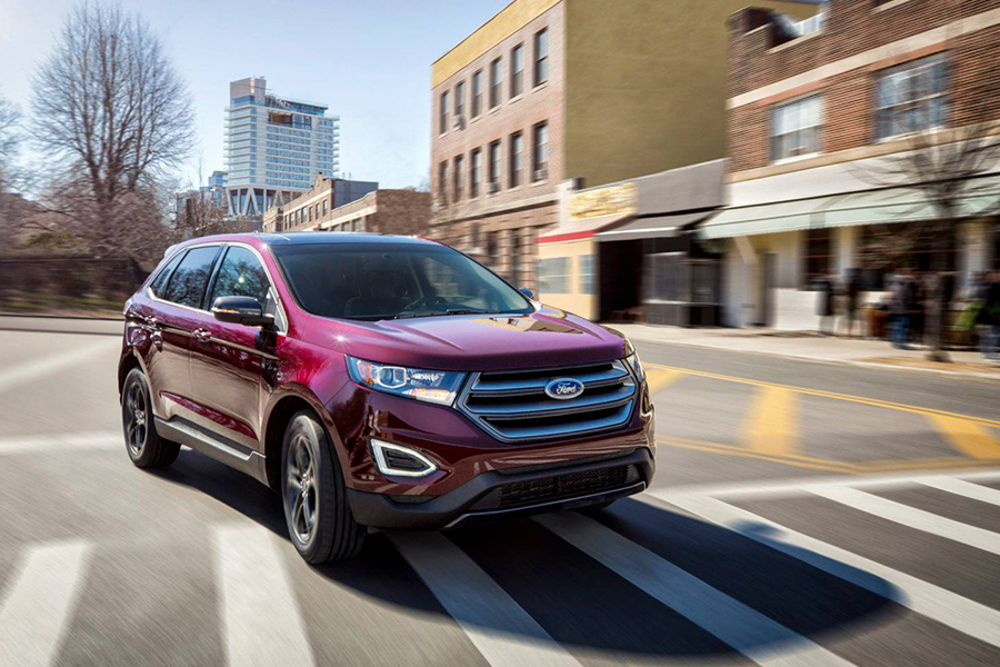 a red 2018 ford edge driving through the city