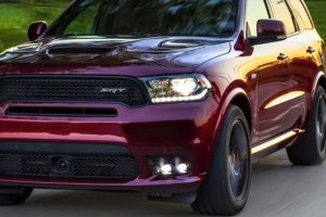 the front end of a maroon 2019 dodge durango driving down the street