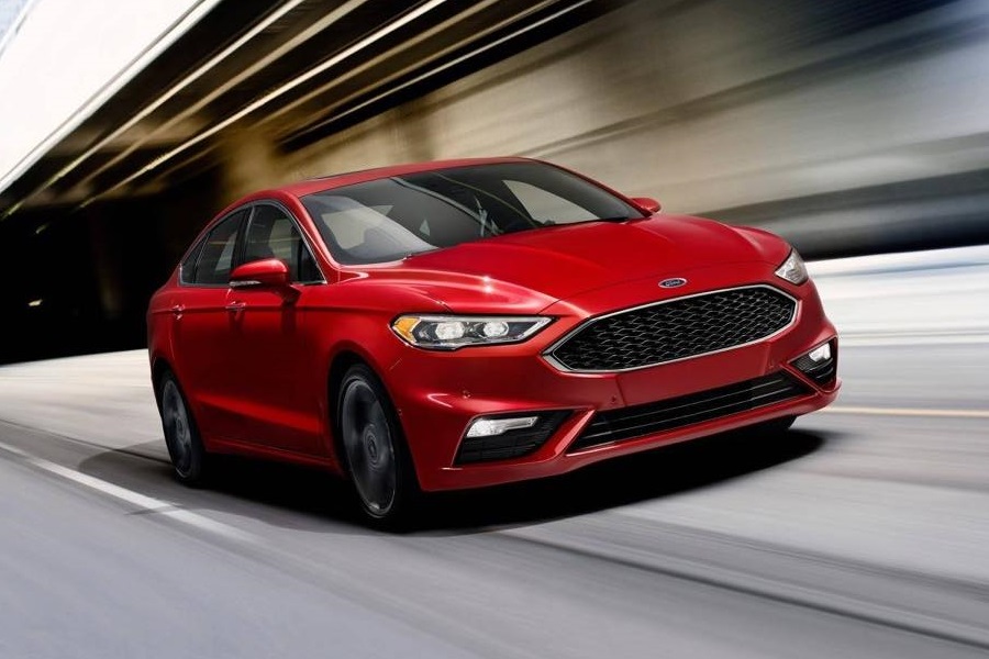 a red 2018 ford fusion driving down the road