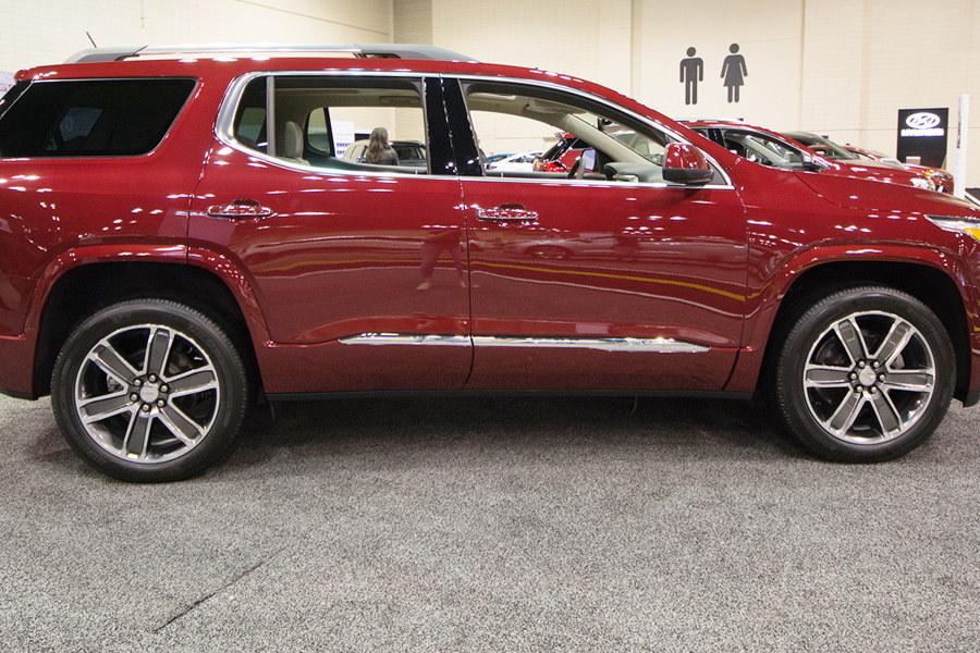 a red 2019 gmc acadia at an auto show showroom