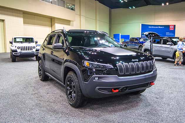 a black 2018 jeep cherokee at an auto show