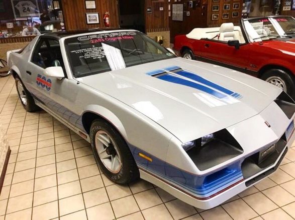 a white chevy camaro with blue racing stripes