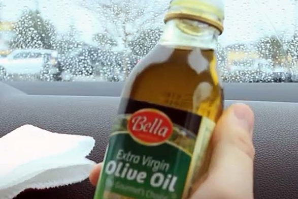 a bottle of olive oil being held in a car