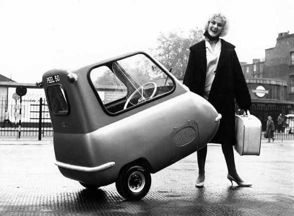 a black and white photograph of a woman lifting up a peel p50 to show how light it is