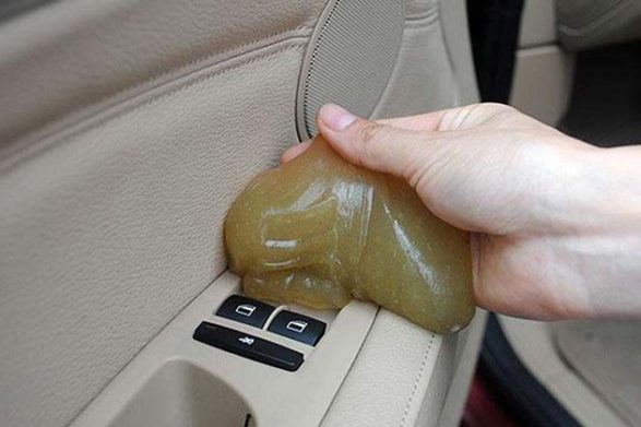 a childrens sticky goo toy being used to pick up dust in a car