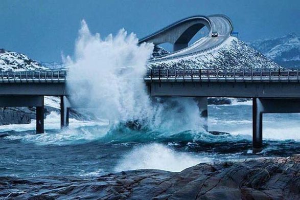 a wave crashes into the atlantic ocean road in norway