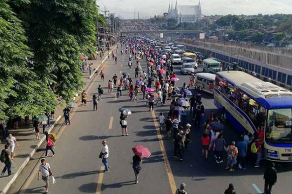 hundreds of people walk along the congested commonwealth avenue in the philippines