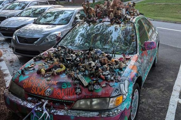 a car covered in dolls glued to the hood and roof