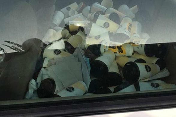 a car with the back seat completely filled with mcdonalds coffee cups