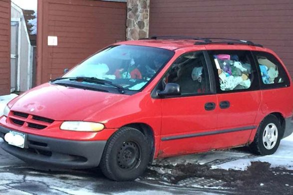 a red dodge van filled with trash up to the windows