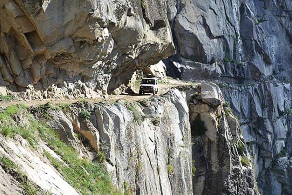an suv travels along the gravel road of the killar to pangi road in india