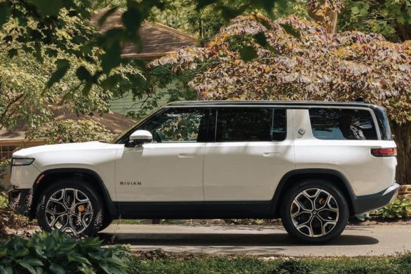 a white rivian r1s parked in a driveway