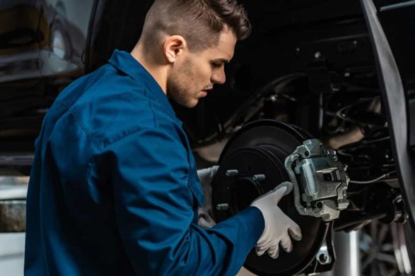 a mechanic repairs car brakes