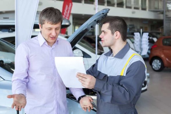 a mechanic explains a bill to a male customer who is unhappy