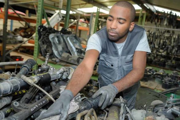 a mechanic examines an older car engine