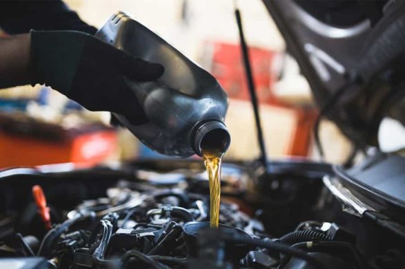 pouring oil into the car engine