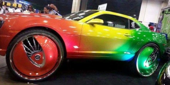 a sports car painted in a rainbow gradient paint job including the rims