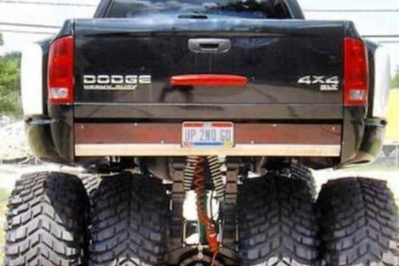 view of the rear of a lifted dodge ram that has 4 wheels across the back