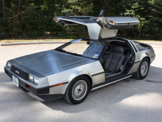 a silver dmc delorean with its gull-wing doors opened