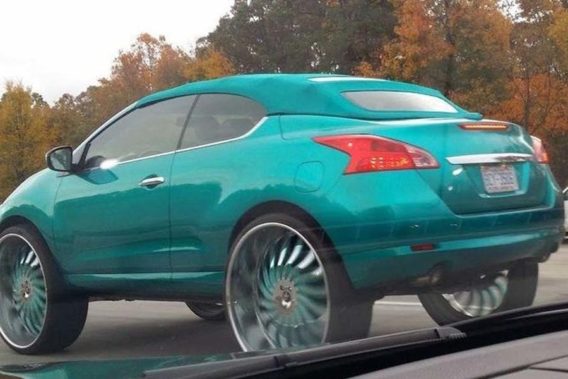 a teal coupe convertible with a matching teal cloth top and teal rims