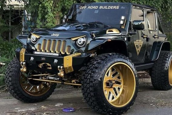 a black and gold jeep with headlights designed to make the front of the vehicle look like an angry face