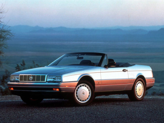a silvery gray cadillac allante convertible with the top down