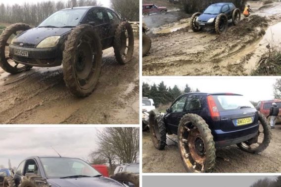 a small ford focus that is mudding with tires almost as big as the car itself
