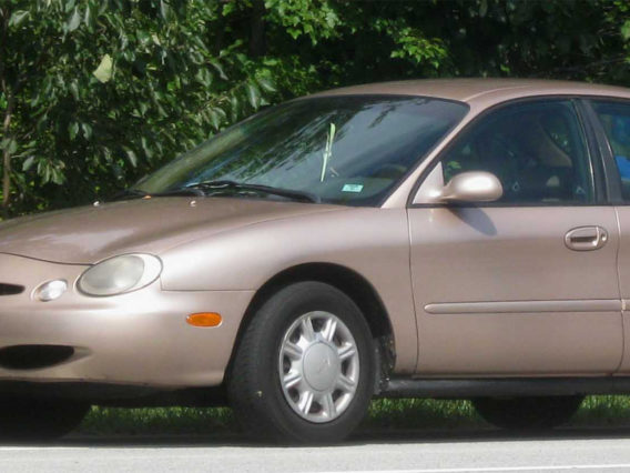 a shiny light copper colored ford taurus