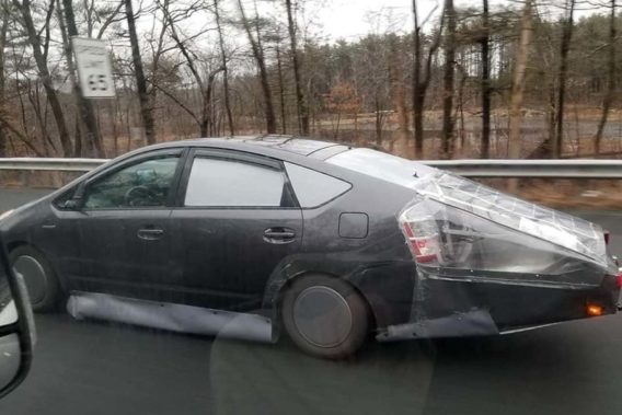 a car with plastic coverings duct taped on it as a DIY fix