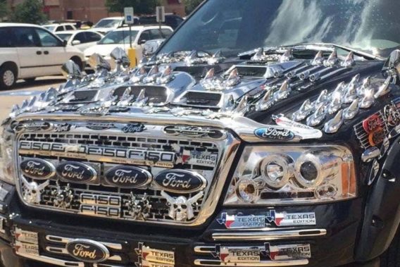 the hood of a ford truck completely covered in chrome stick ons and ford texas stickers