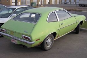 a notorious green ford pinto in a parking lot