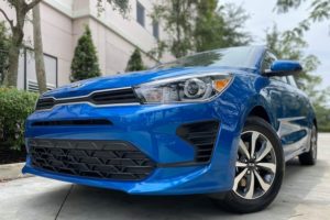 a close up of the front grille of a blue 2021 kia rio